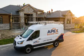 A branded work van for Apex Roofing displaying the company name and roofing services.